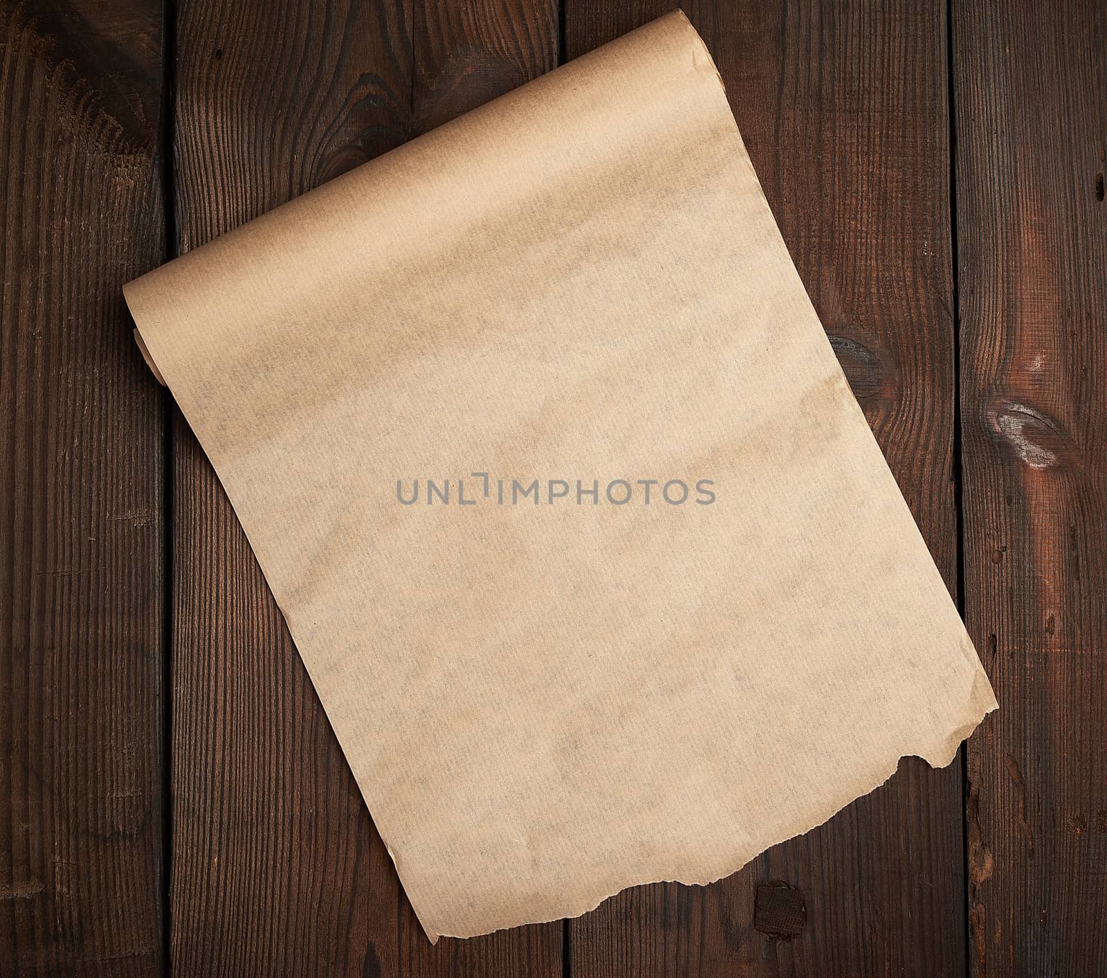 roll of untwisted brown paper on a wooden surface from old boards, copy space