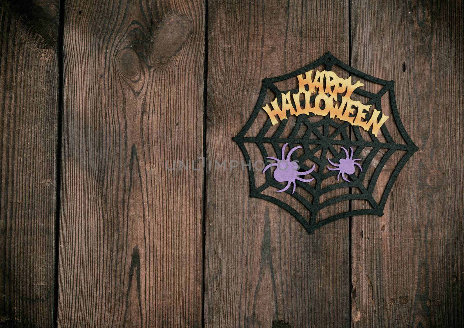 felt figures of the web, spider for the holiday of Halloween on a brown background, top view