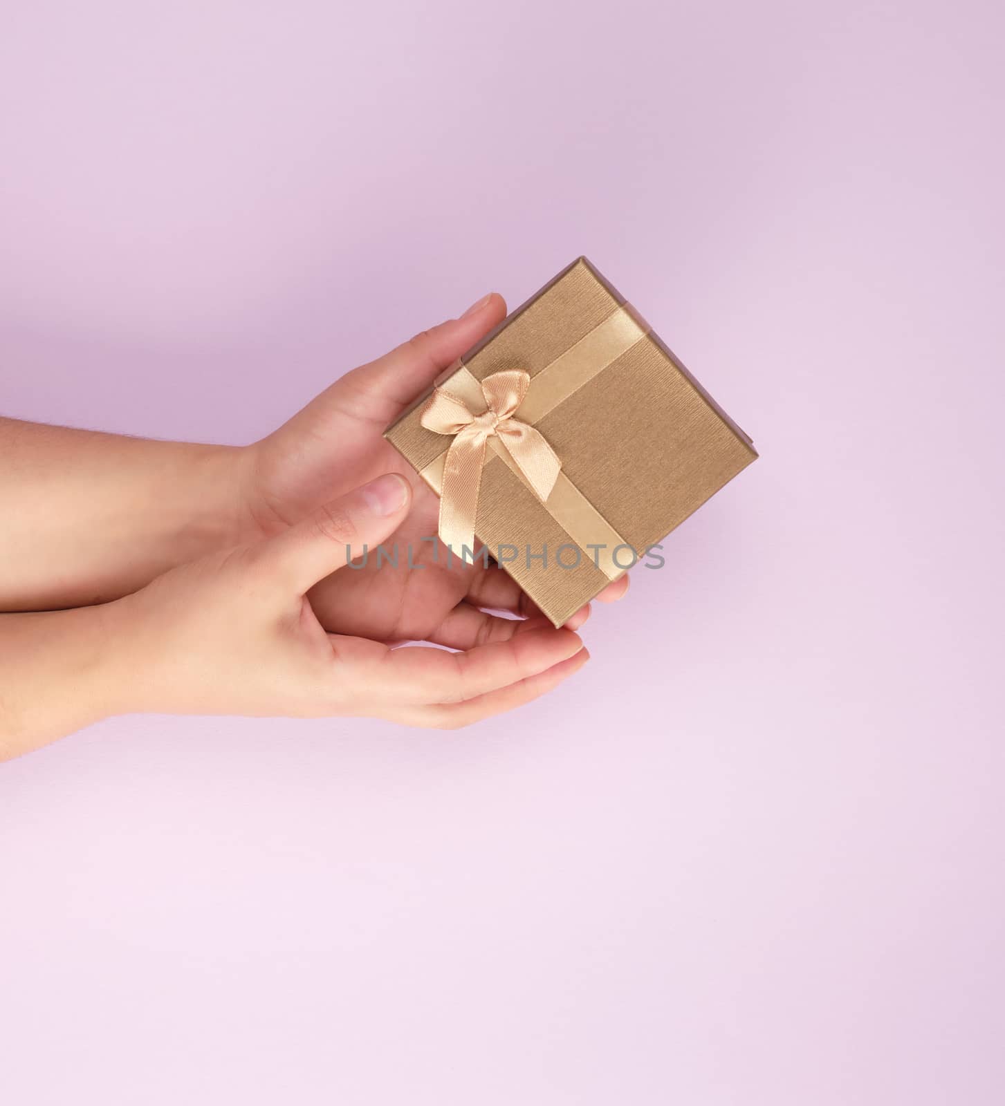 girl hold a brown square box on a purple background, top view, concept of giving gifts