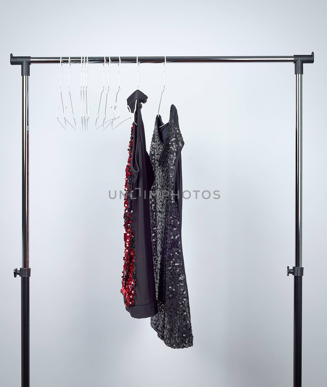 fashionable black women's sequined blouses hanging on white iron hangers, white background, sales concept