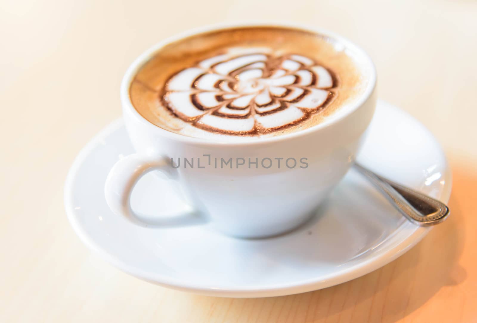 hot cappuccino coffee with nice pattern foam on table by rukawajung