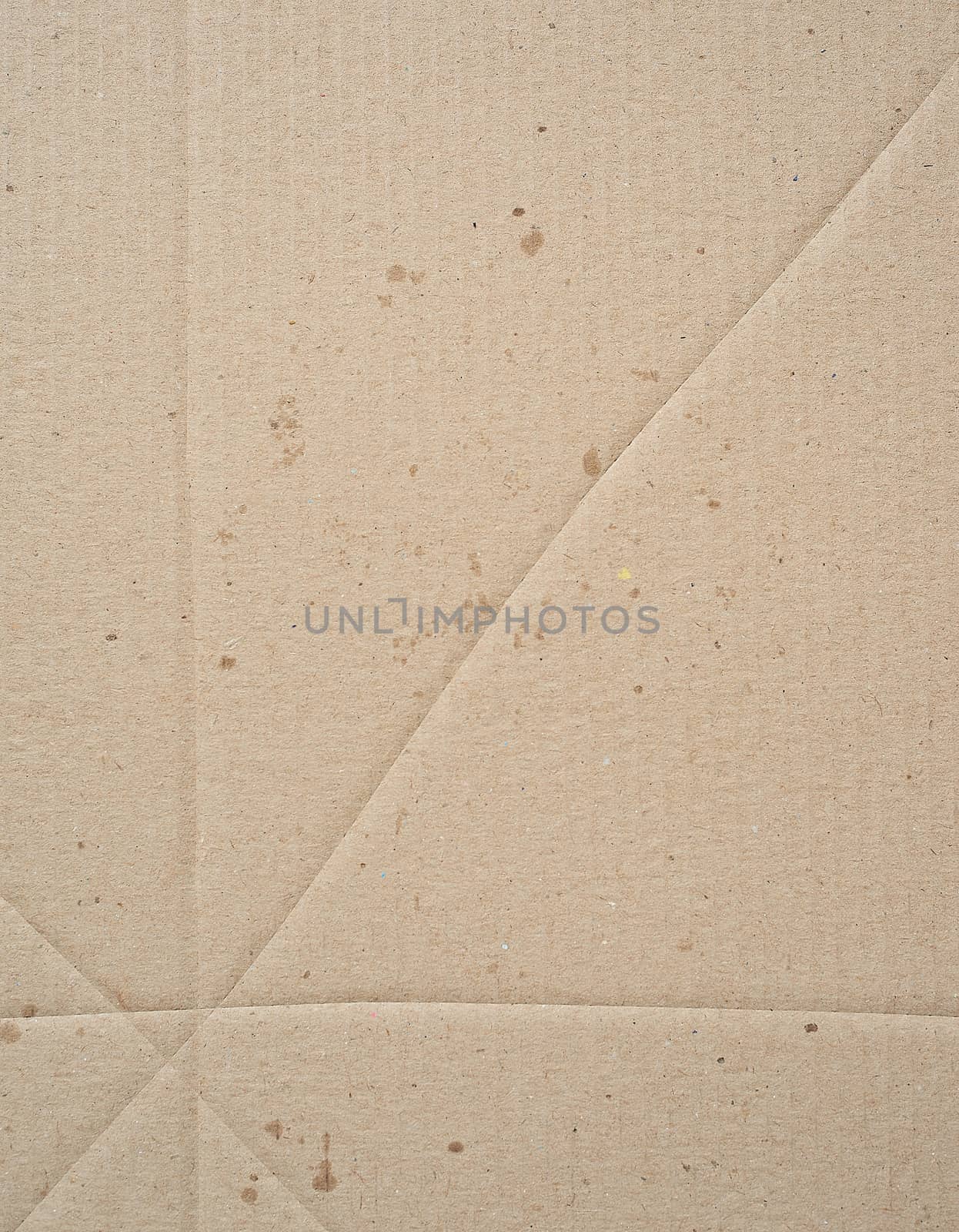 fragment of a brown paper sheet of a box with greasy stains, close up