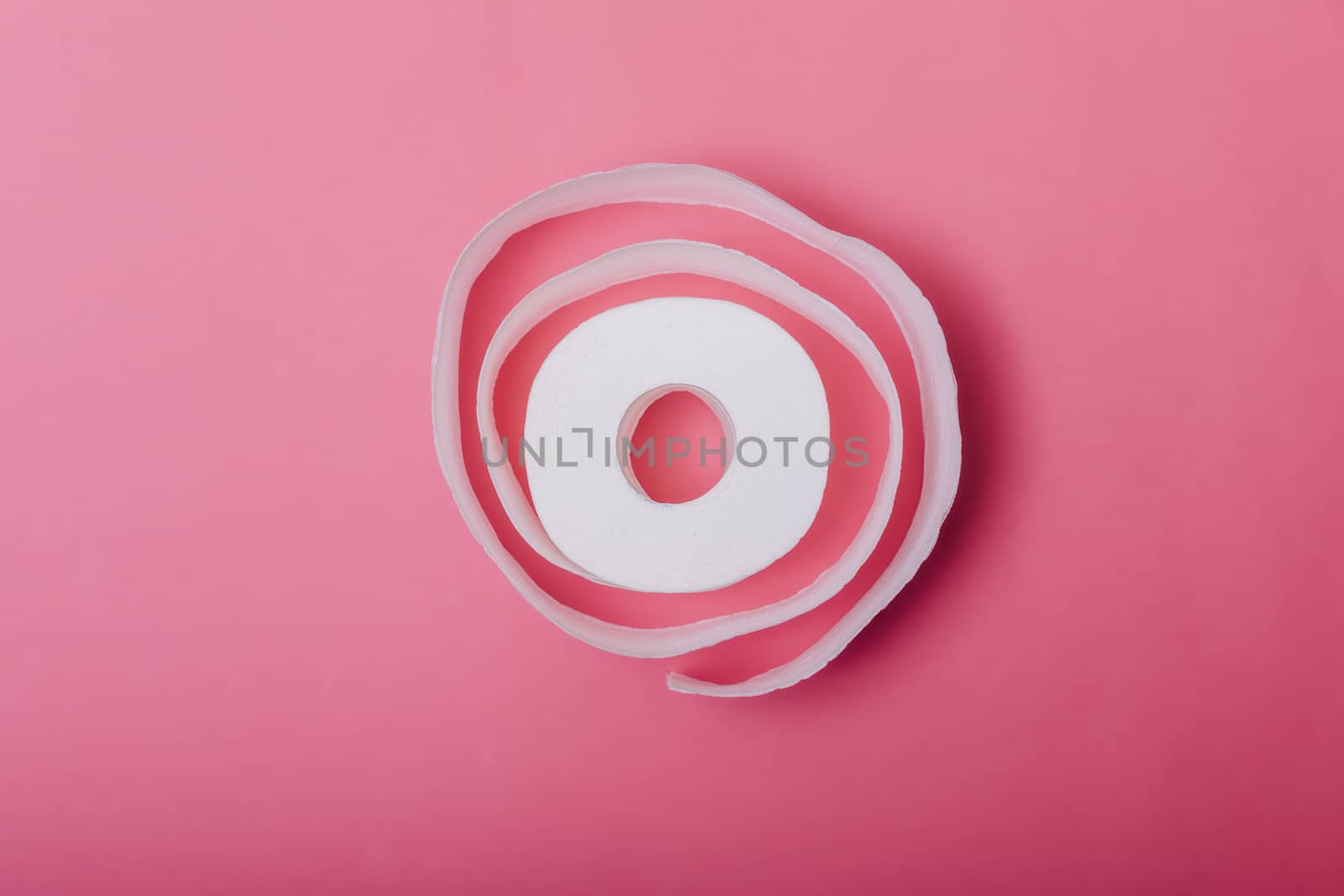 Conceptual image of toilet paper roll standing alone at pastel background. Roll of toilet paper on a pastel pink background. Coronavirus covid-19 design. by boskorelly
