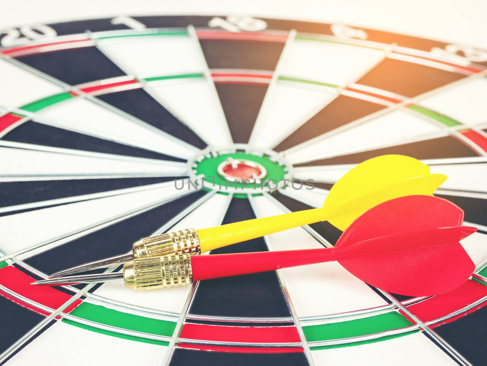 Red and yellow Dart arrows and dartboard with light