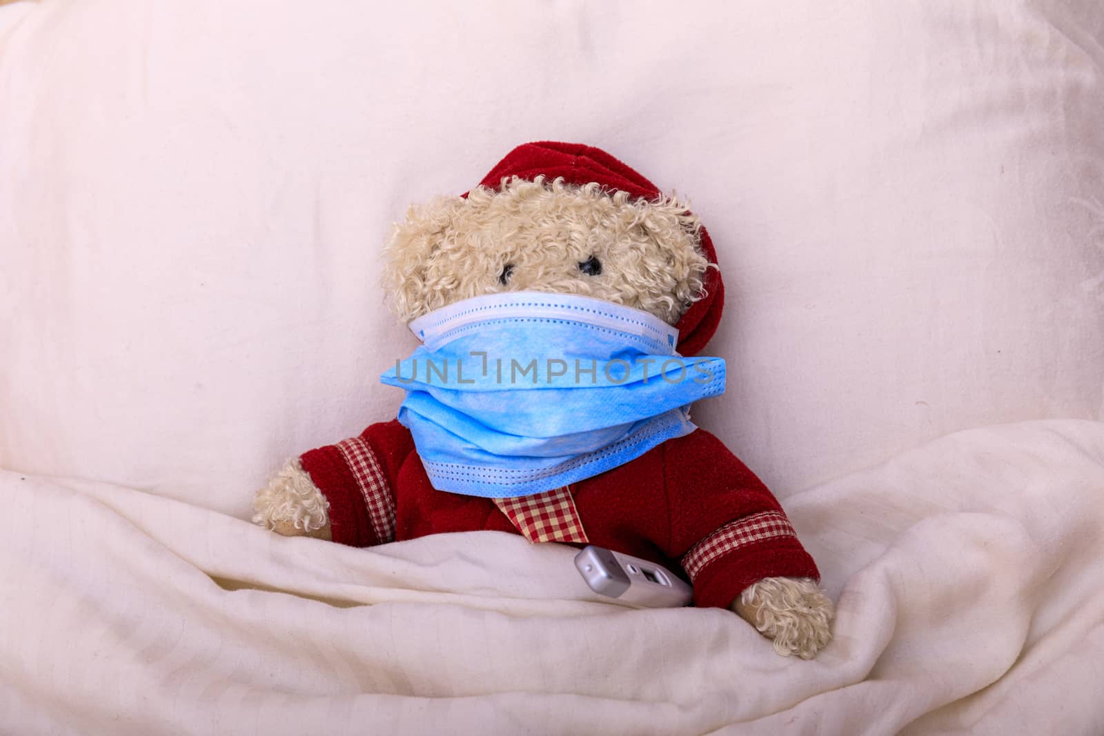 Teddy bear in a medical mask in the bed. Respiratory medicine. Children and illness COVID-2019 disease concept. Home quarantine at Coronavirus.