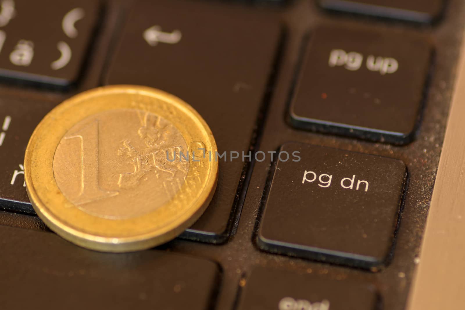 Euro coins lie on a laptop keyboard. Close up, space for text. Concept of working on the Internet or online payment for purchase. Laptop keyboard and coin 1 Euro.