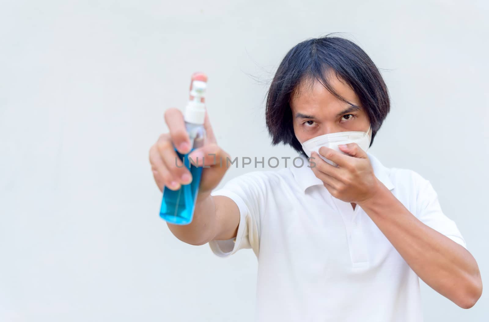 A asian man wear mask and spray the alcohol gel for cleaning disease by rukawajung