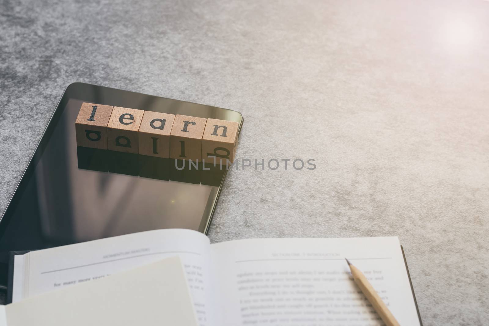 Cube letter word of Learn with tablet, notebook, textbook, pencil with copy space. Photo concept of online course of business and education, academic and literature e-learning, long distance learning