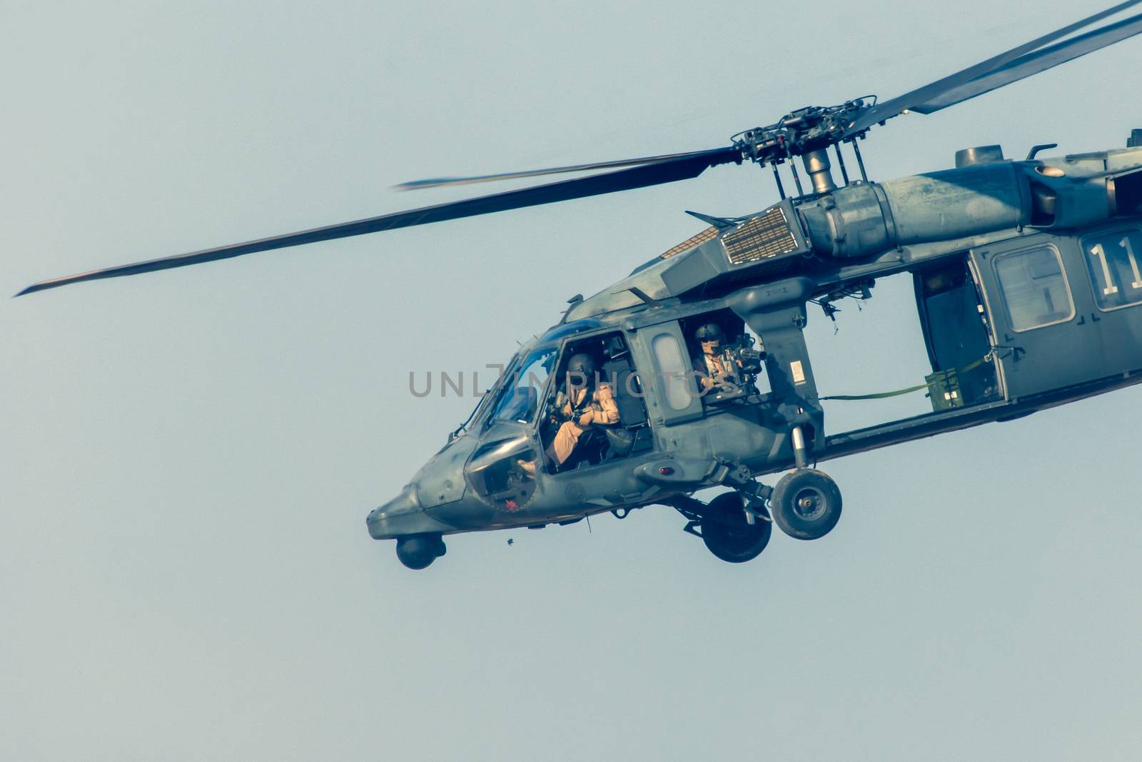 Military chopper close up shooting in war flies through the sky. Military concept of power, force, strength, air raid.