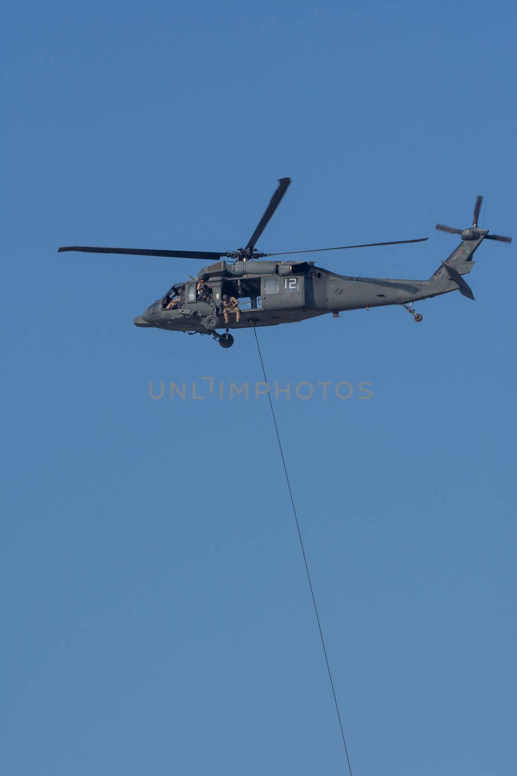 Military team in conflict resucing people by helicopter. dropping a rope attached to chopper in the MIddle East conflict.
