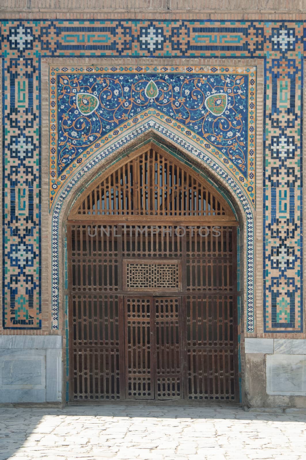 Wooden door with ancient traditional Asian ornamentation and mosaics. the details of the architecture of medieval Central Asia