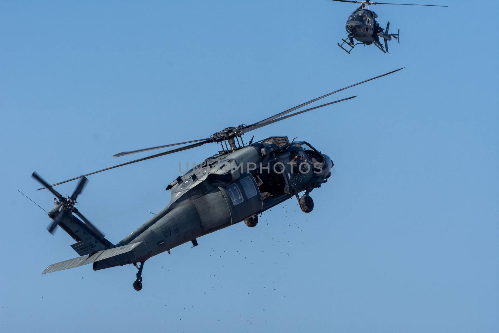 Two Military choppers shooting machine guns in combat and war fl by kingmaphotos