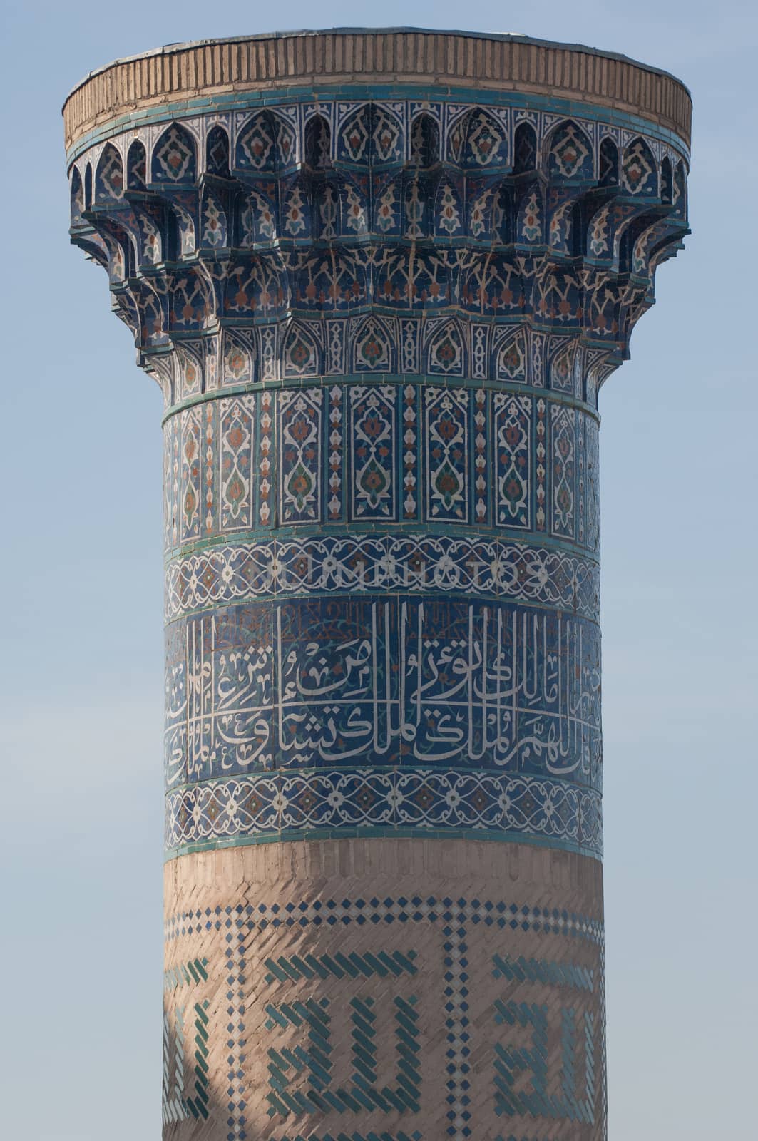 Closeup of the top of the tower with a mosaic of quite ancient Asian buildings. the details of the architecture of medieval Central Asia