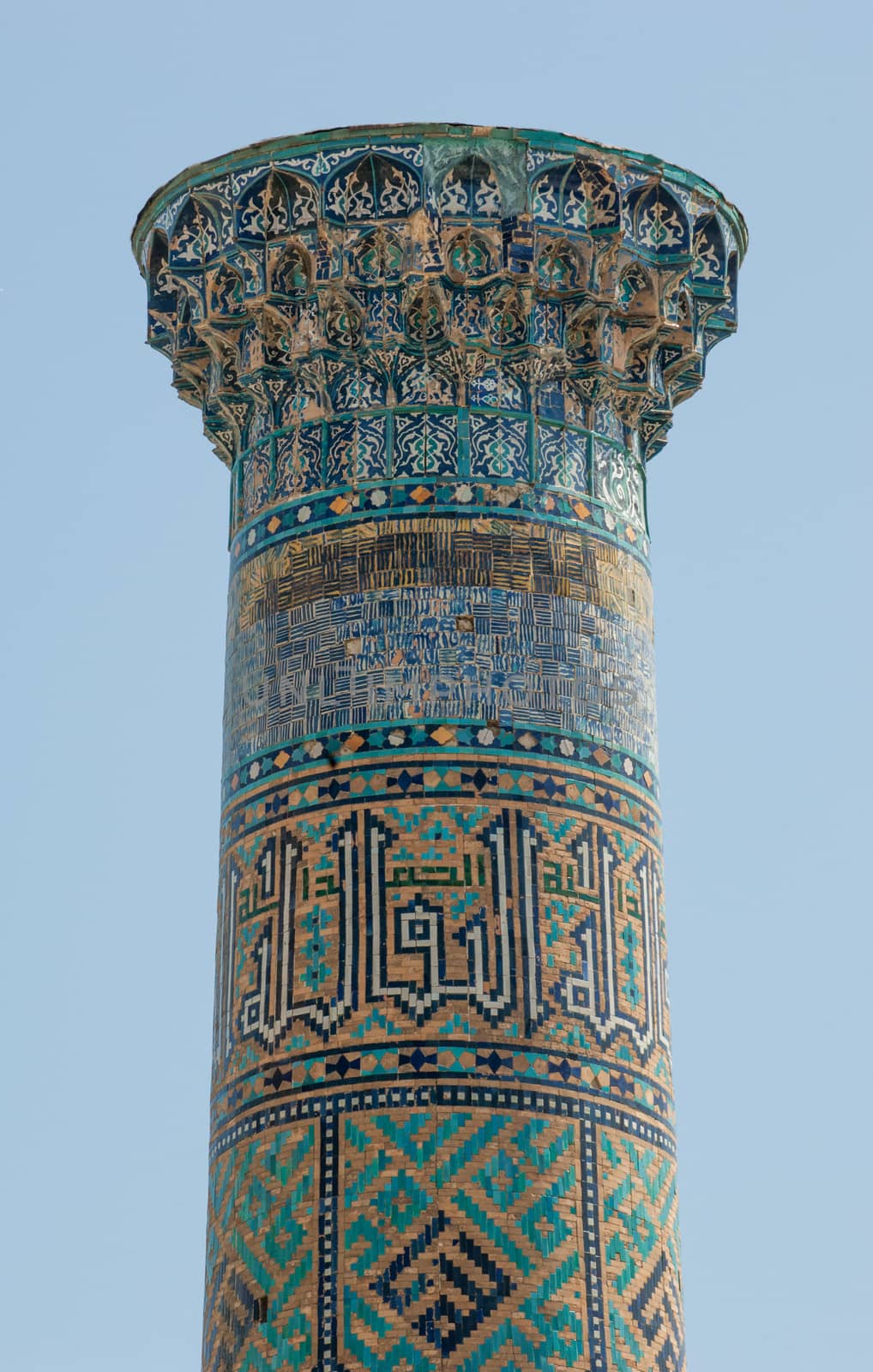 Closeup of the top of the tower with a mosaic of quite ancient Asian buildings. the details of the architecture of medieval Central Asia