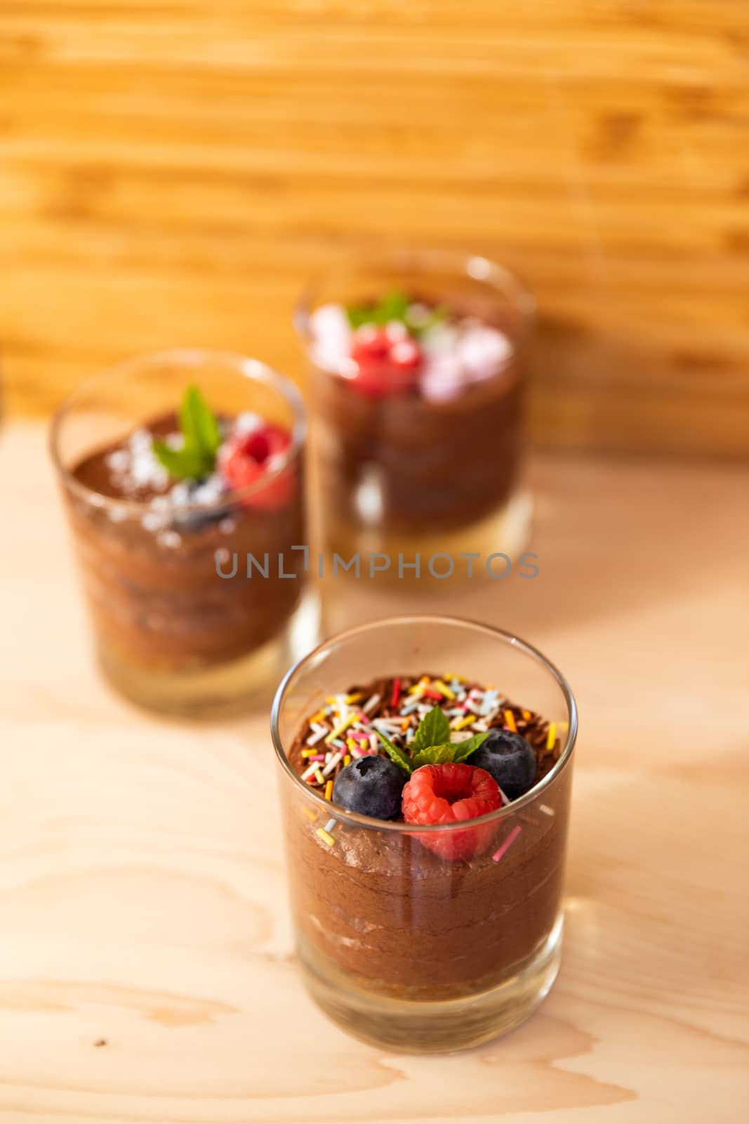 Top view shot of glasses filled with delicious mousse chocolateGroup shot with glasses filled with chocolate mousse by camerarules