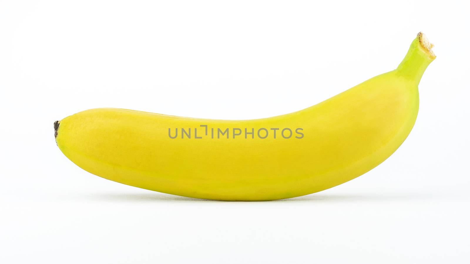 One ripe yellow banana isolated on a white background.