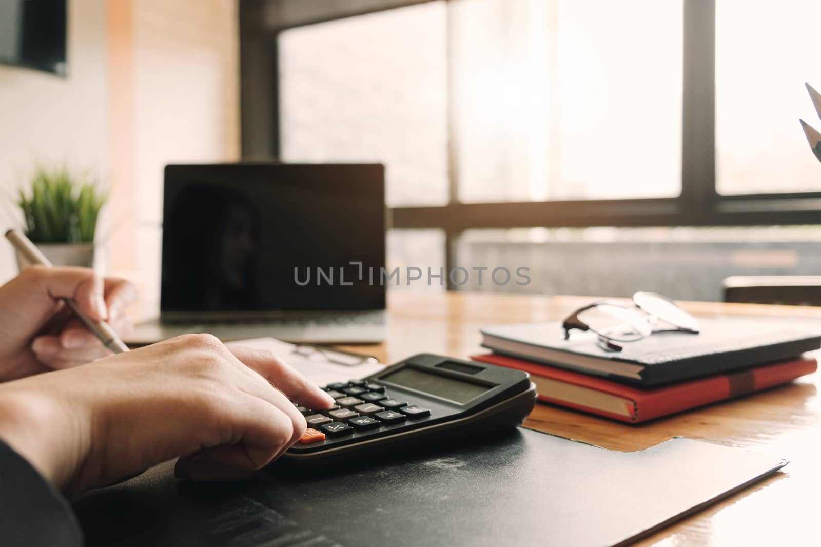 Accountant using a calculator to calculate the numbers. Accounti by wichayada