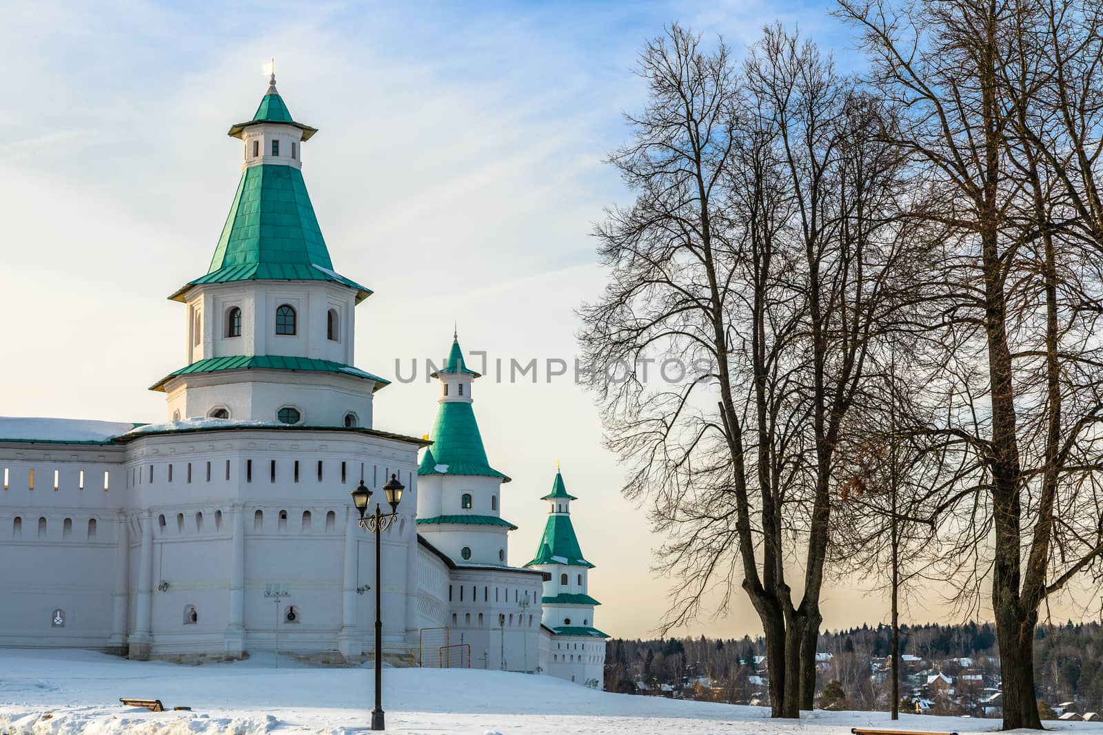 Snow and white towers with green roof of New Jerusalem Monastery fortified walls, Istra, Moscow region, Russia