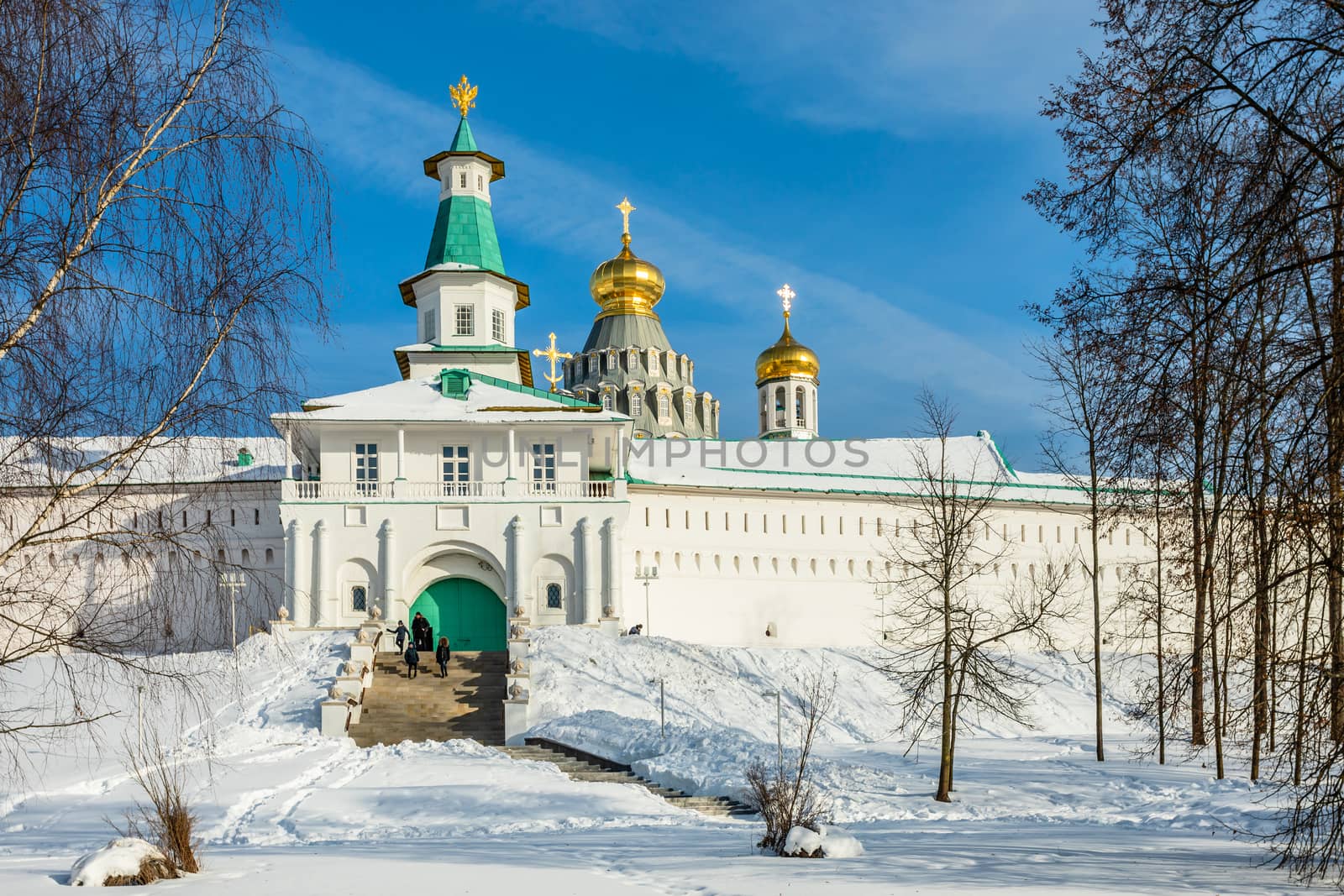 Snow and white walls, golden domes and a tower gate of New Jerusalem Monastery, Istra, Moscow region, Russia