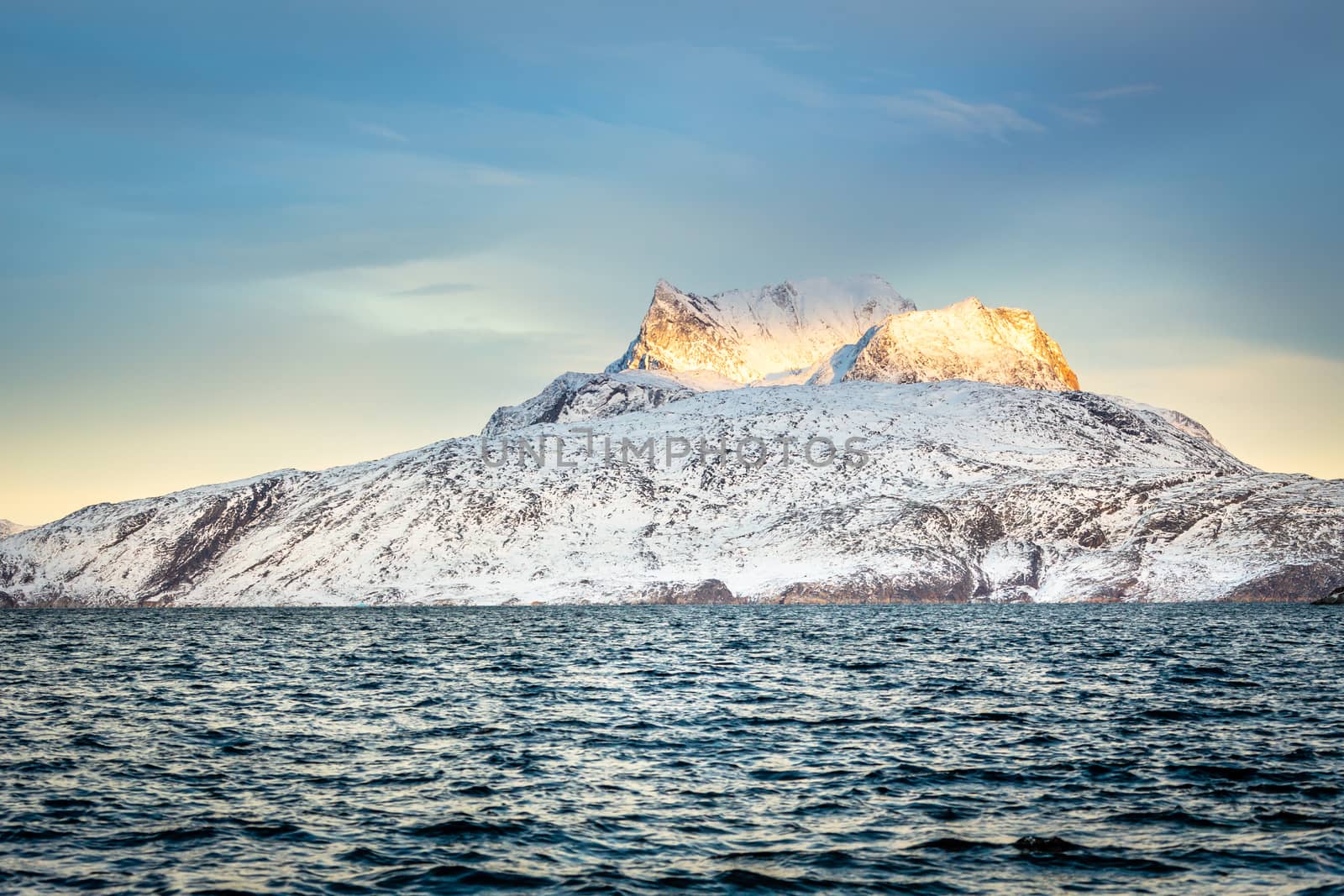 Huge Sermitsiaq mountain covered in snow with sea in the foreground, nearby Nuuk city, Greenland