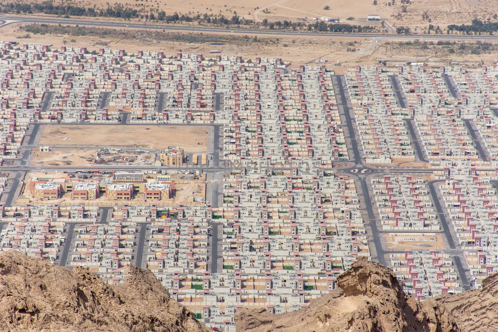 Aerial view of New housing development in Al Ain, Abu Dhabi, United Arab Emirates from Jebal Hafeet mountain top looking at common or same housing design.