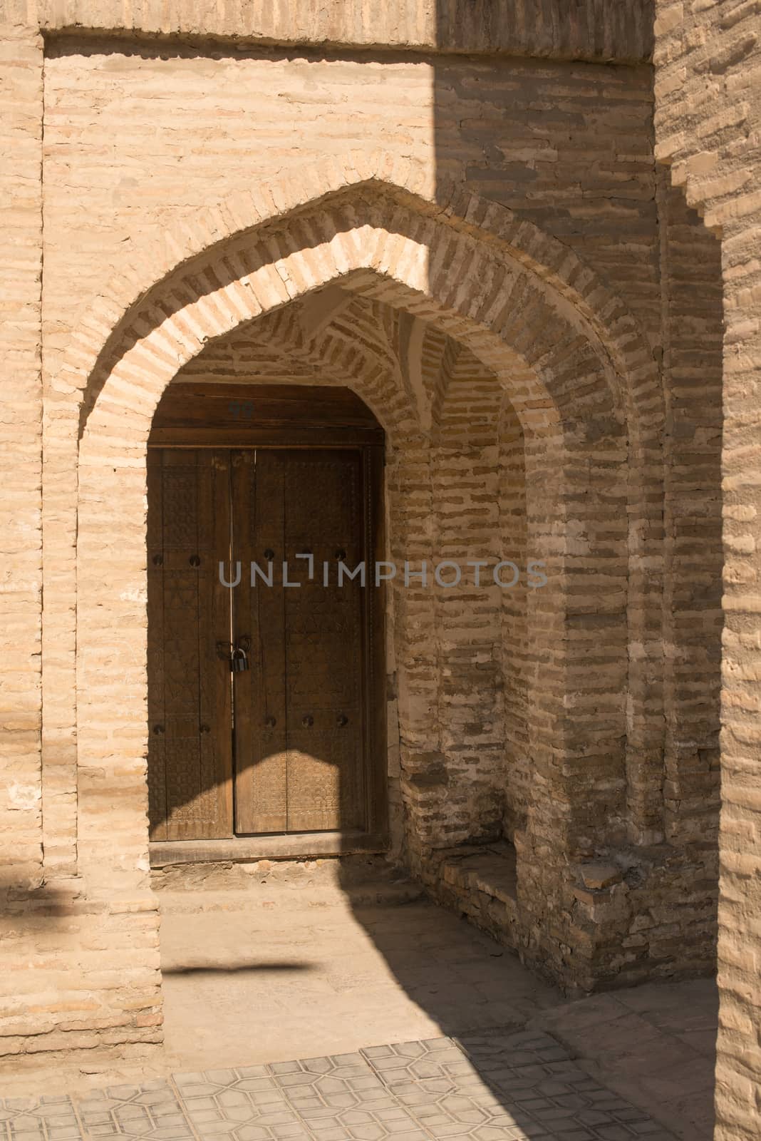 Wooden door with ancient traditional Asian ornamentation and mosaics. the details of the architecture of medieval Central Asia