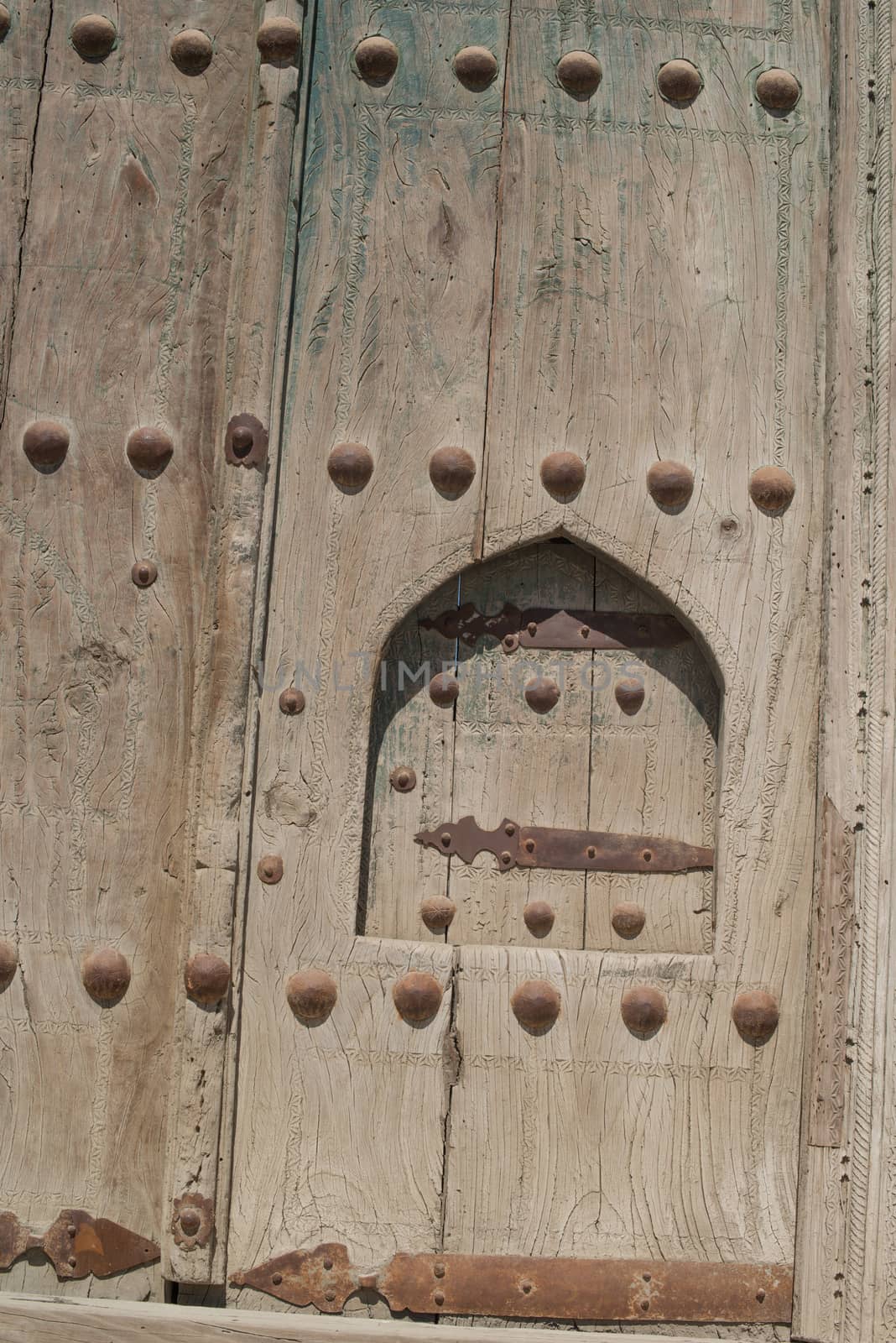 Old wooden door with metal rivets in Bukhara, Central Asia.