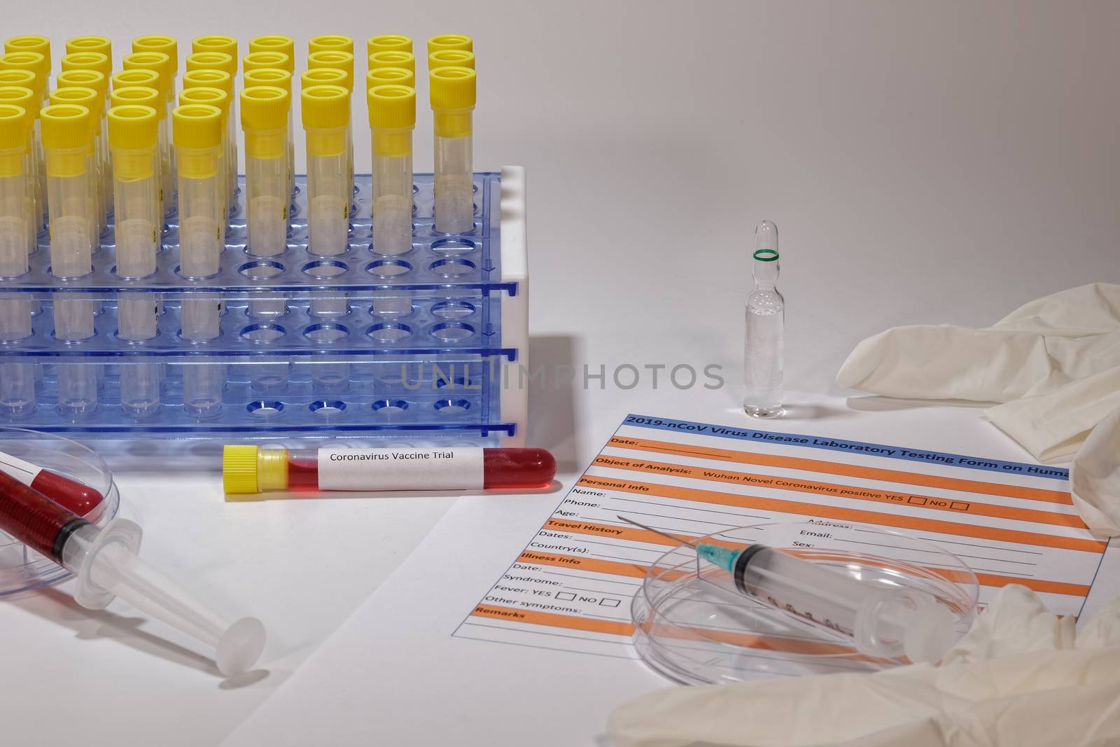 Clinical tests for Wuhan virus with laboratory testing form next to vaccine trial vacutainer blood tube and syringes.
