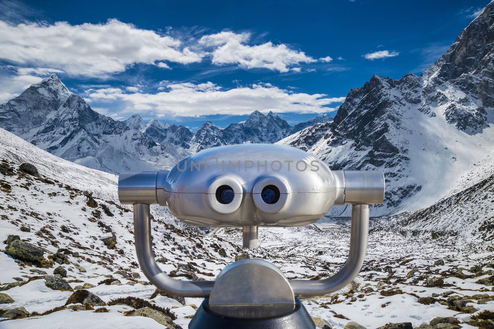 Public binoculars in front of a view over mountain peaks in the  by mbruxelle