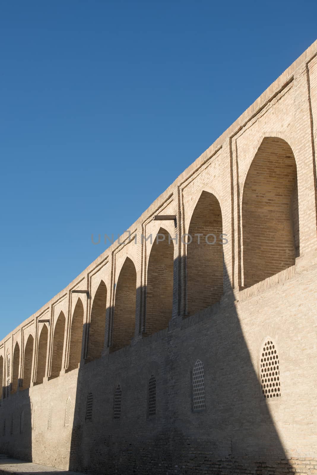 The old building, the wall with arches. Ancient buildings of medieval Asia. Bukhara, Uzbekistan