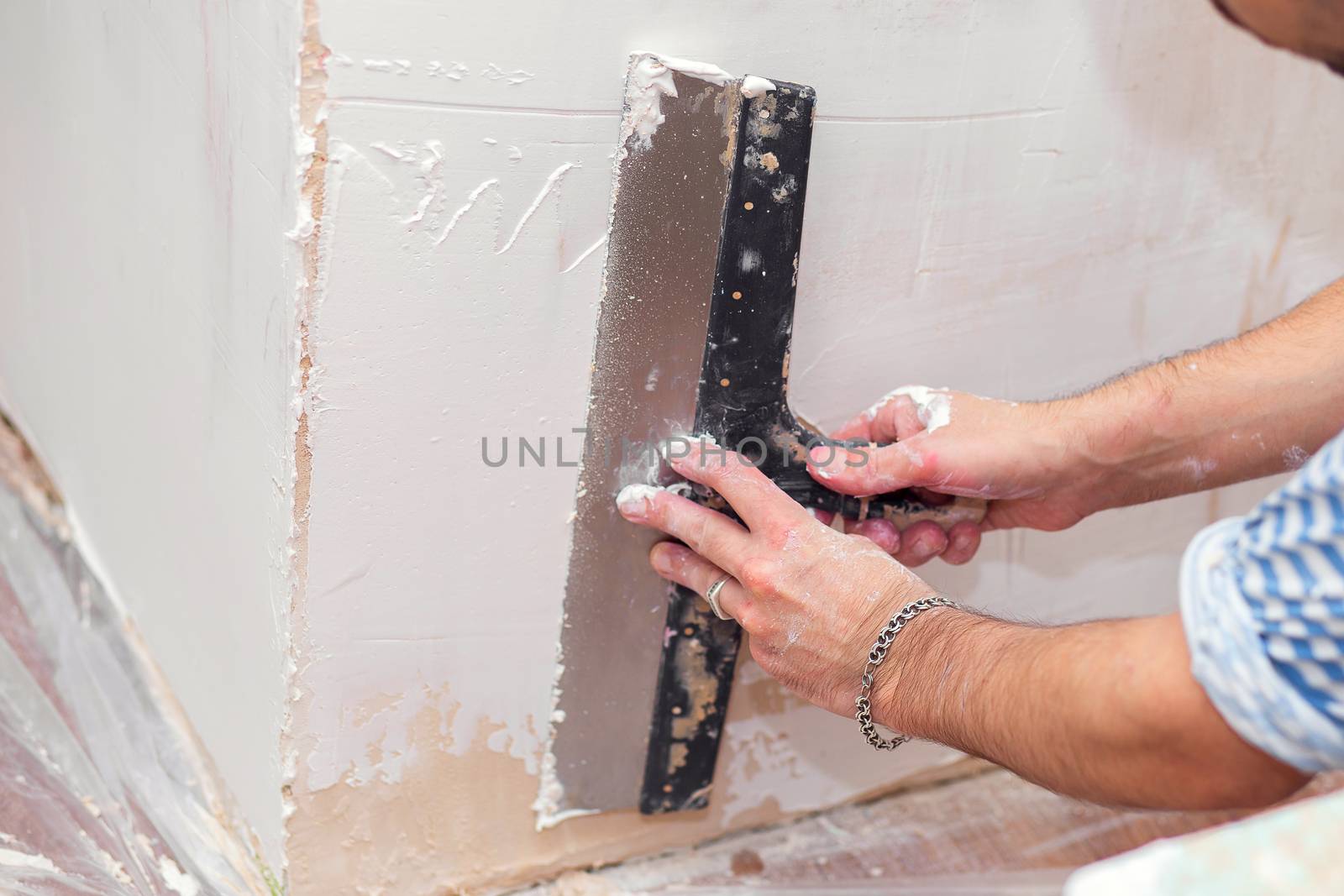 Repair of the living quarters. Putty interior walls with a wide metal spatula.