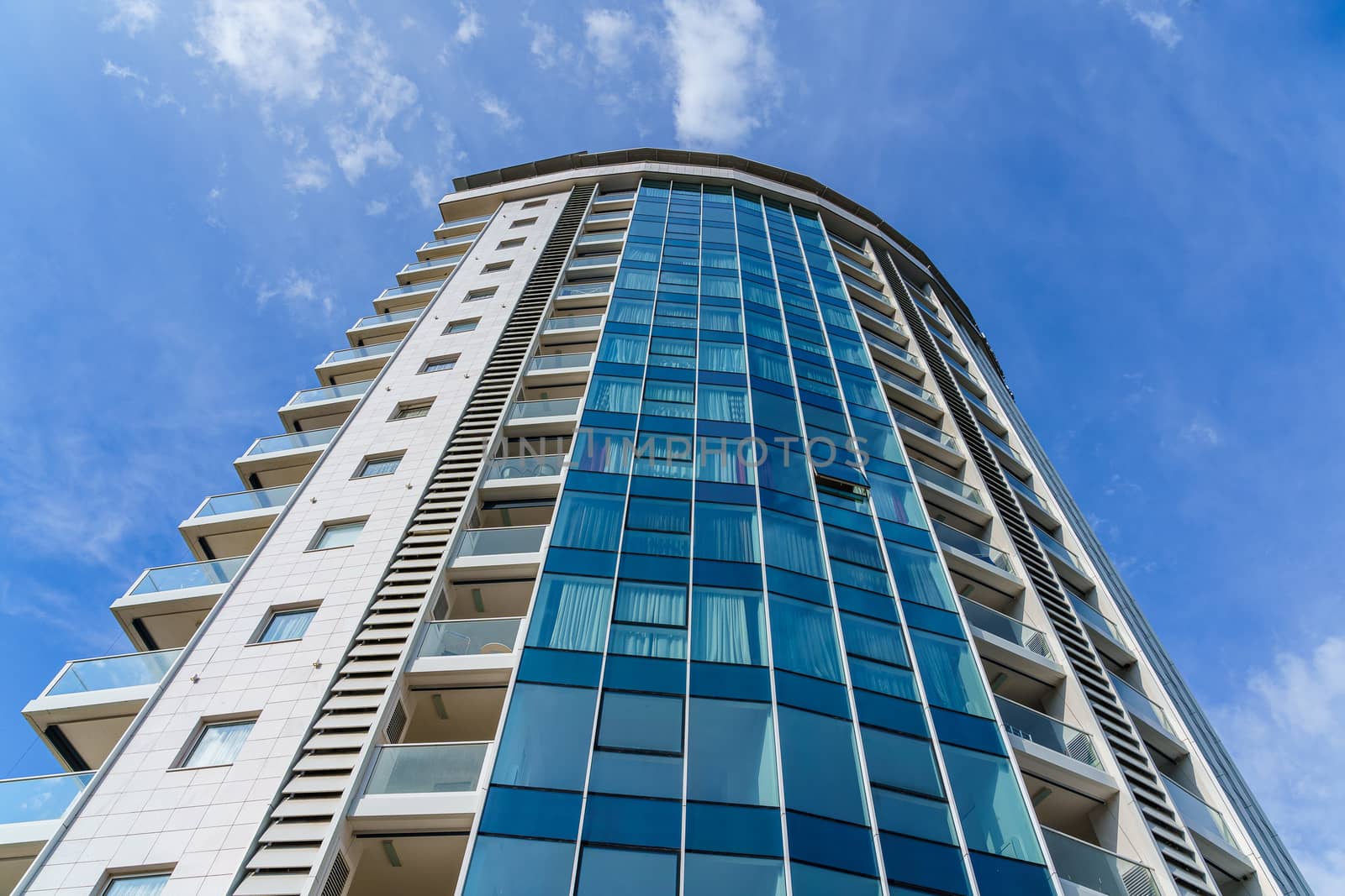 Skyscraper building made of glass and concrete against a blue sky