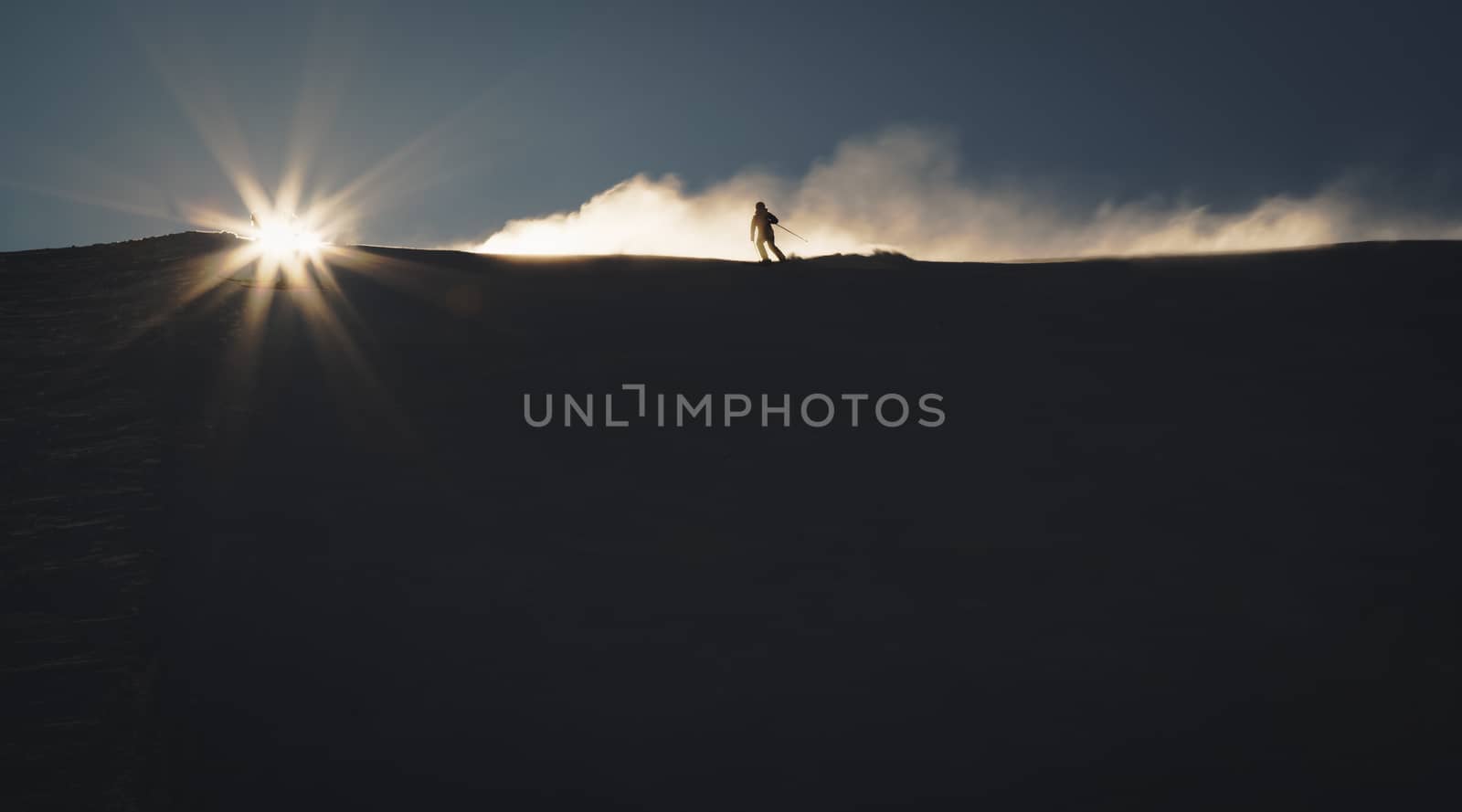 Skier enjoying an early morning in slopes at the Austrian Alps with a nice sunshine backlight