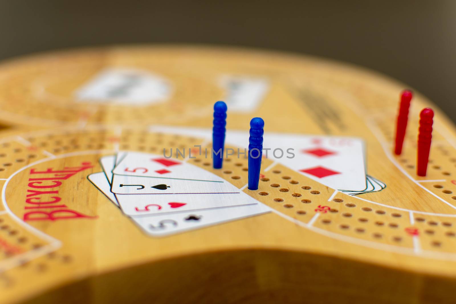 RAK, RAK/UAE - 4/20/2019: "Cribbage card game and board up close looking at the blue and red pegs."