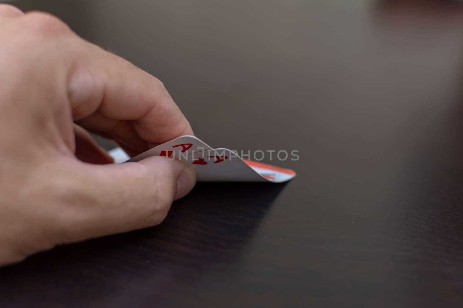 Pocket (pair) of aces in a poker game with a hand and black tabl by kingmaphotos