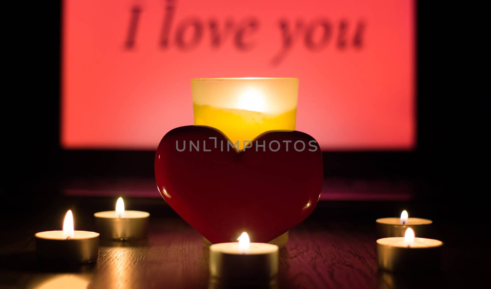 Greeting card for Valentine's day or international women's day. A red heart stands against a background of lighted candles and the inscription I love you. Christmas fortune telling and Divination fate