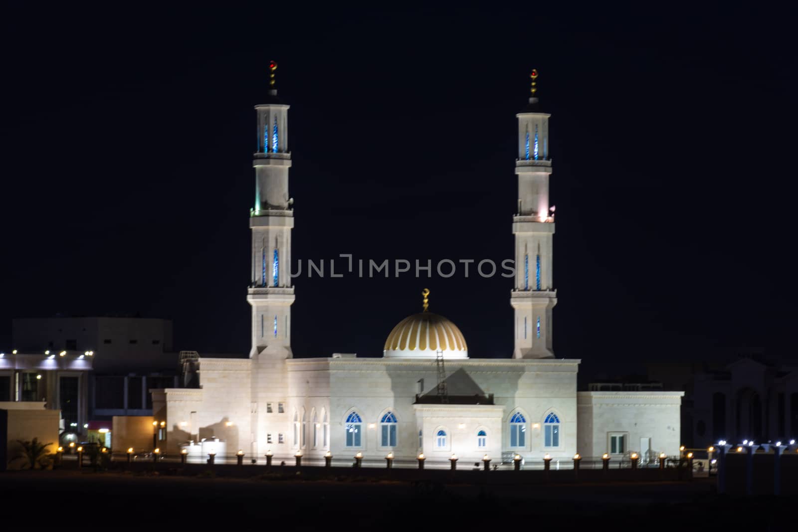 White Mosque Glowing at night in the Middle East during call to  by kingmaphotos