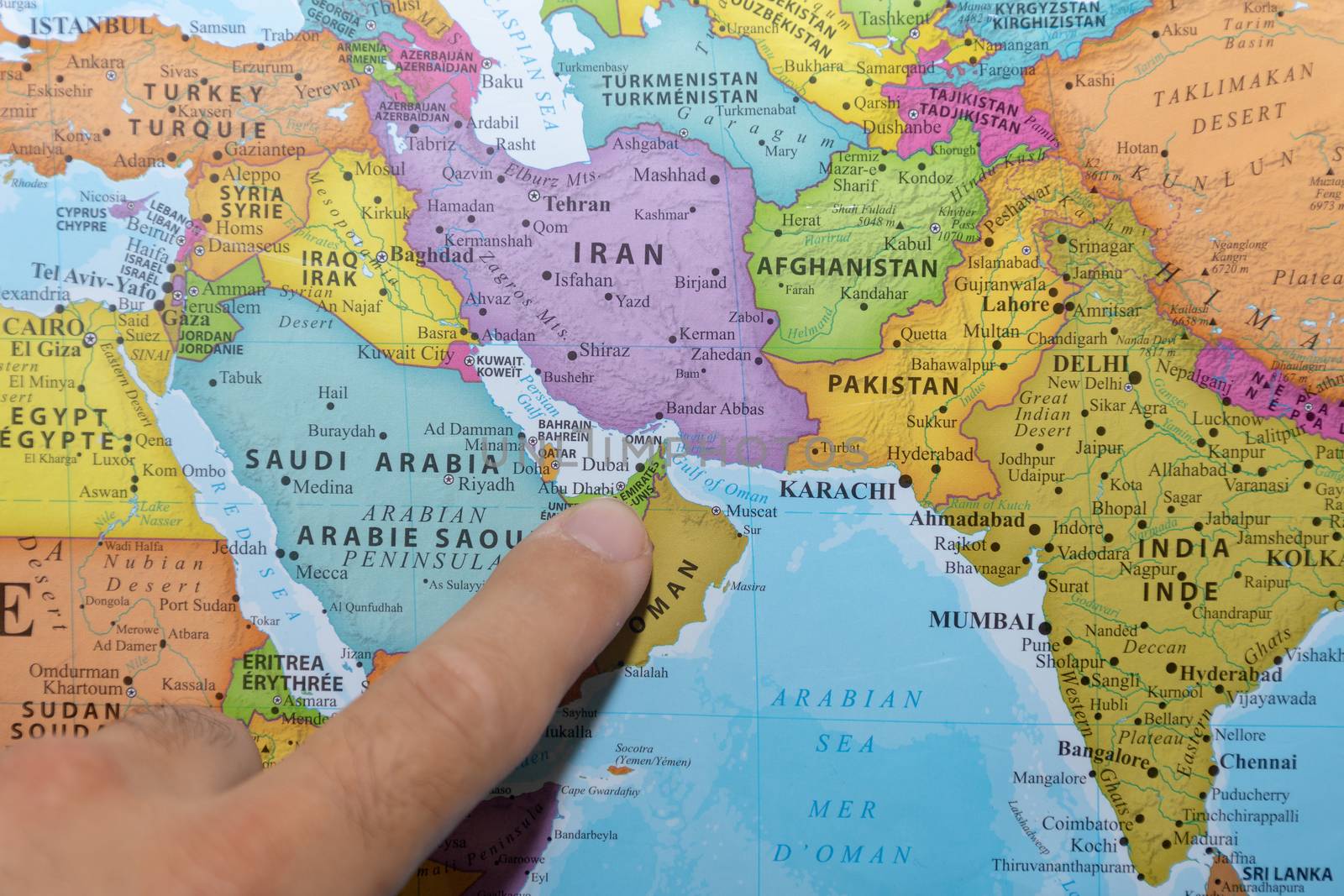 Finger pointing to a colorful country map of the United Arab Emi by kingmaphotos