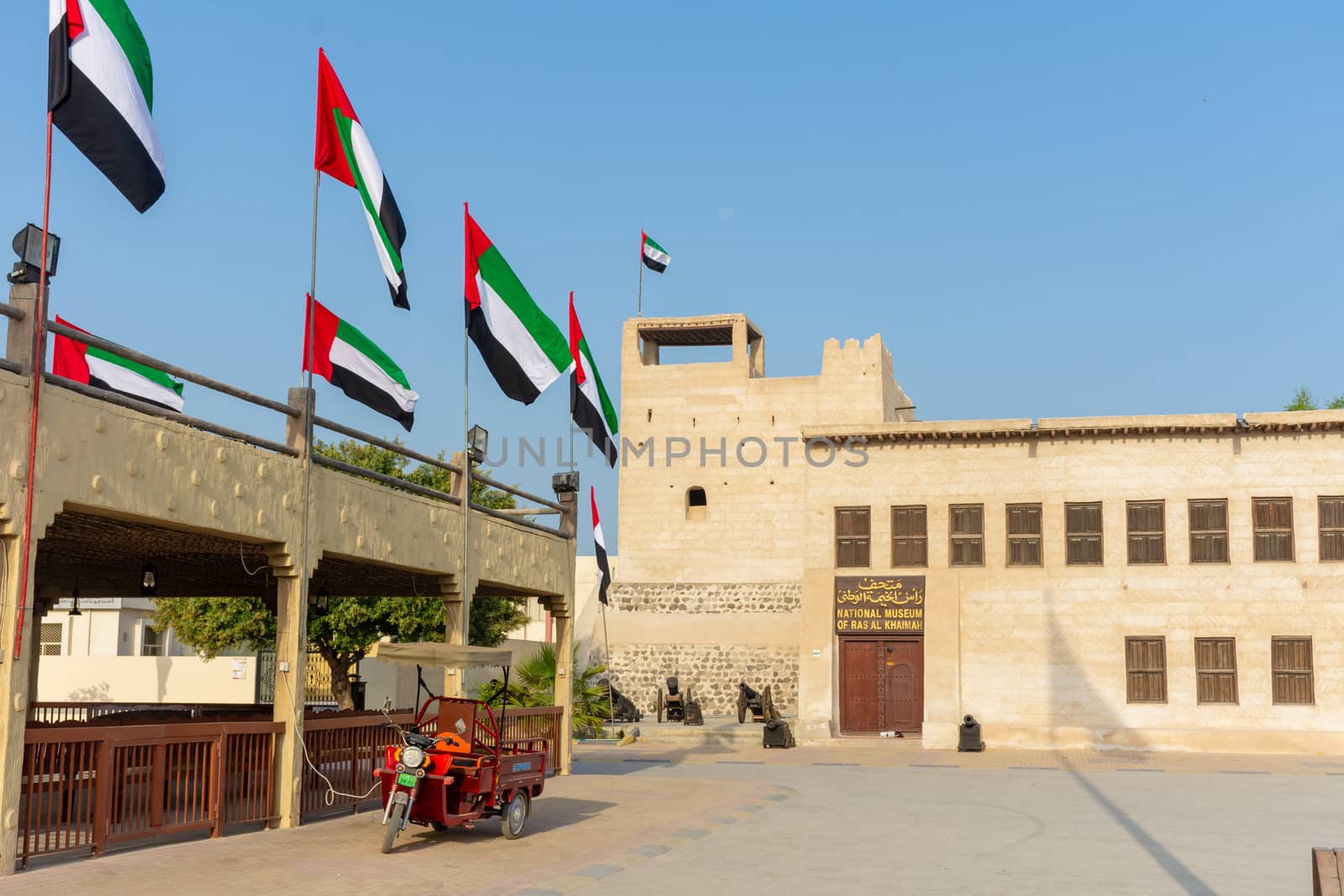 Entrance of the Ras al Khaimah Museum in the morning sun with flags blowing.