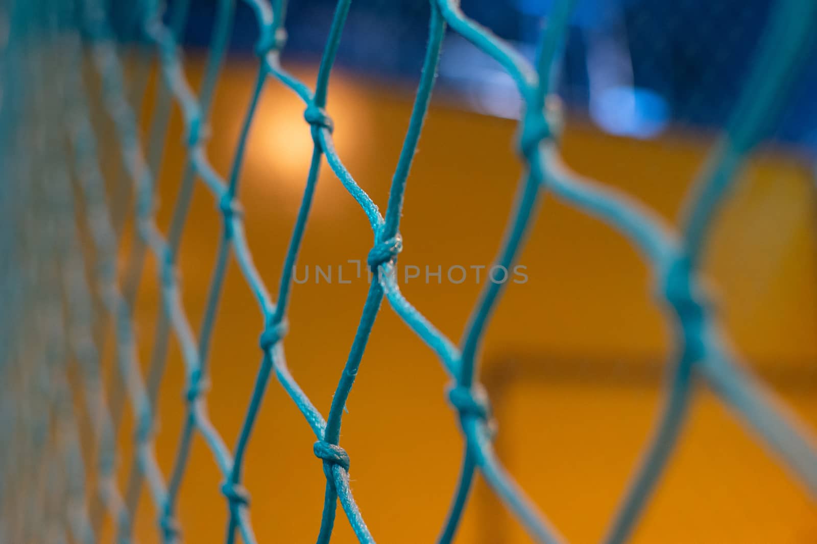 Looing through a blue net to a yellow and blue background blurre by kingmaphotos