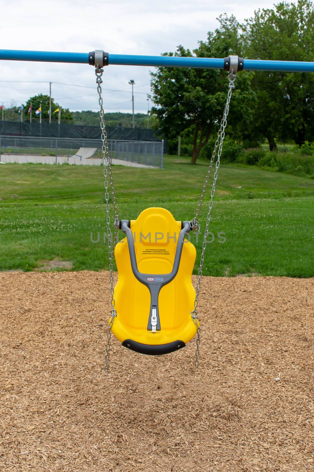 "Brighton, Ontario/Canada - 07/22/2019: Little tikes yellow disability swing for handicapped or special needs children at a park."