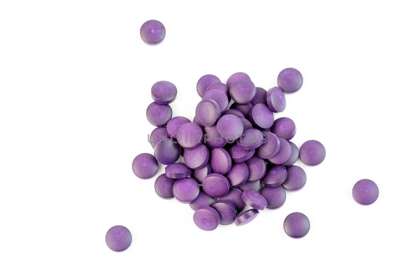 a small pile of purple compacted powder pills isolated on white background in linear perspective.