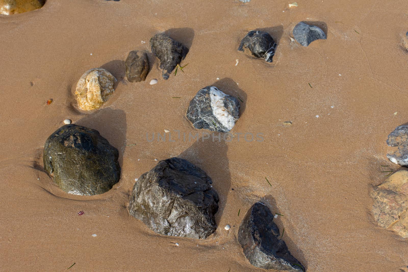 Rocks on the beach seashore in the sand and water. Quiet, peaceful concept.
