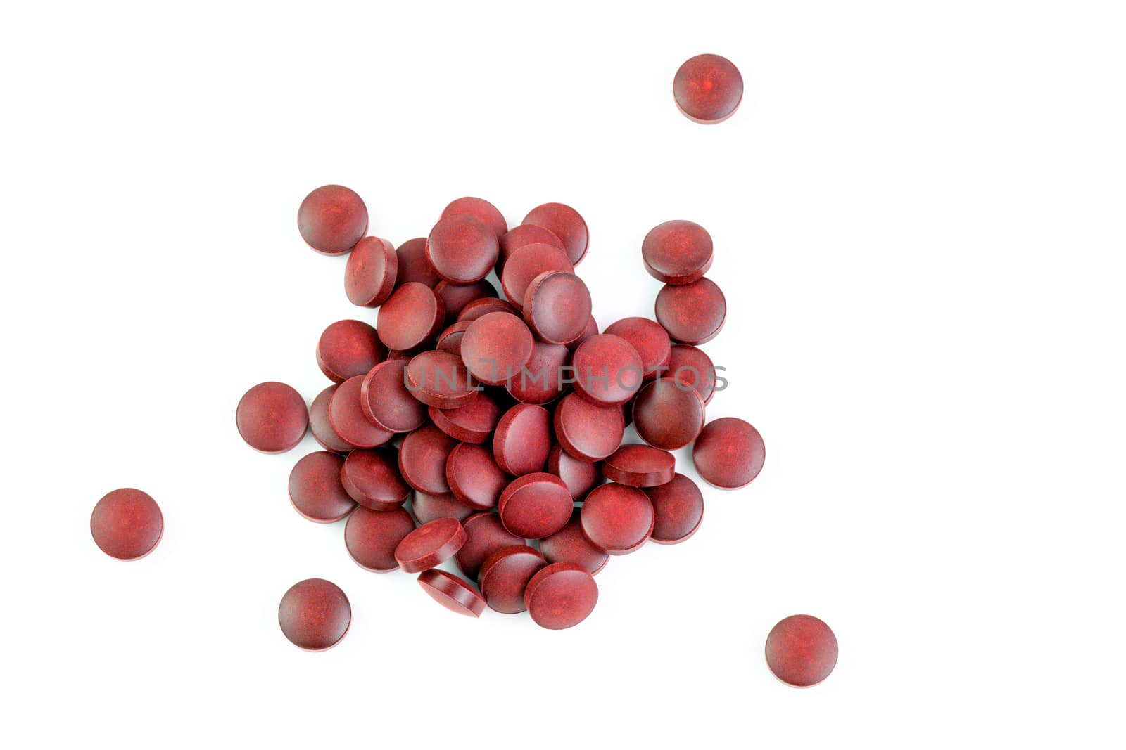 a small pile of red compacted powder pills isolated on white background in linear perspective by z1b