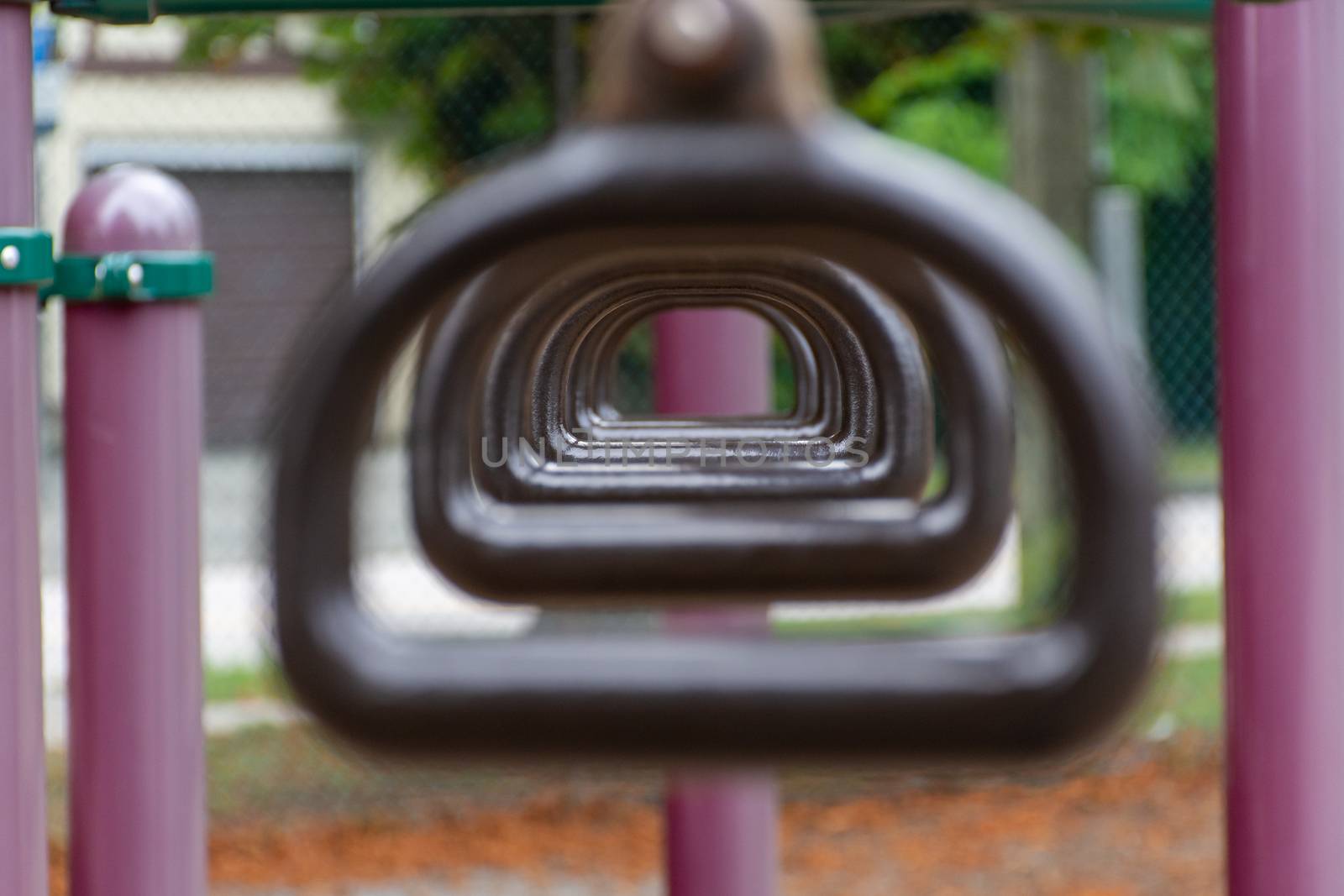 Empty monkey bars at a playground conecept looking through rings by kingmaphotos