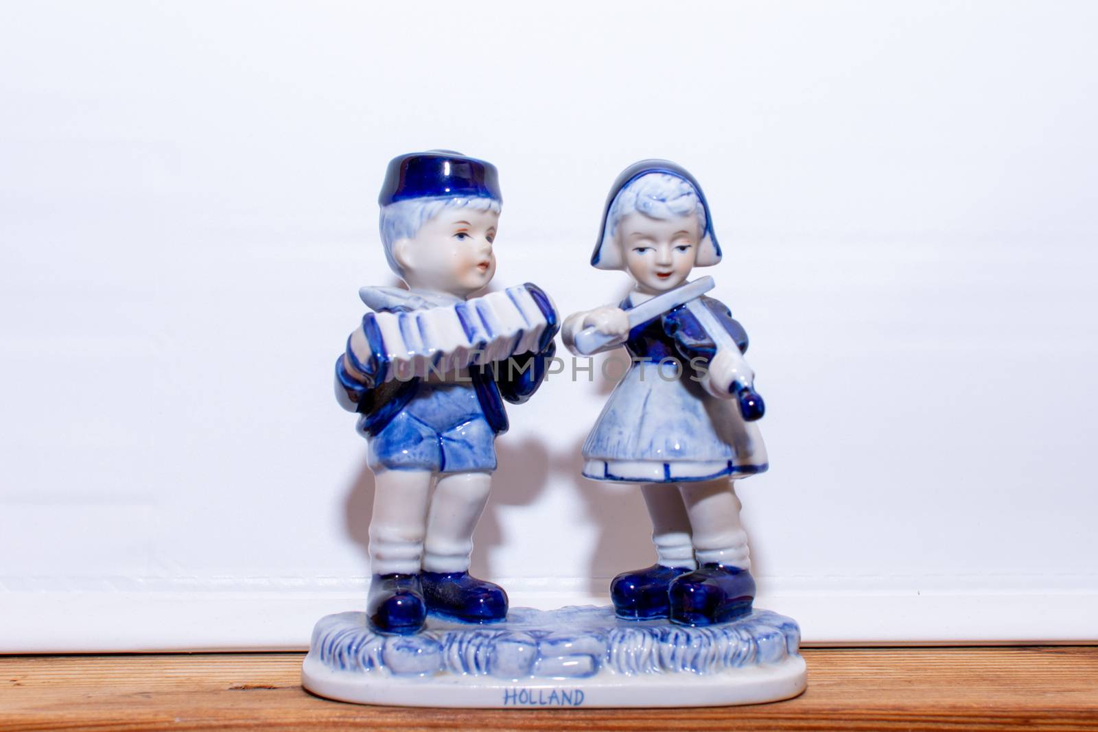 Delft Blue Figurine of Dutch couple playing music on a violin and accordian. Souvenir from Holland/Netherlands. Isolated on white background.