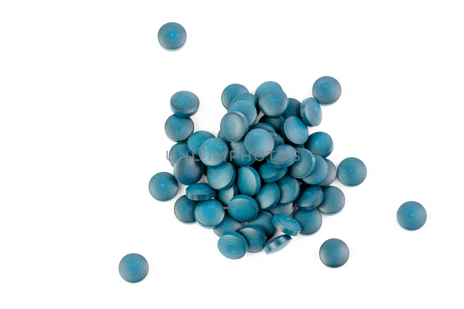 a small pile of blue compacted powder pills isolated on white background in linear perspective by z1b