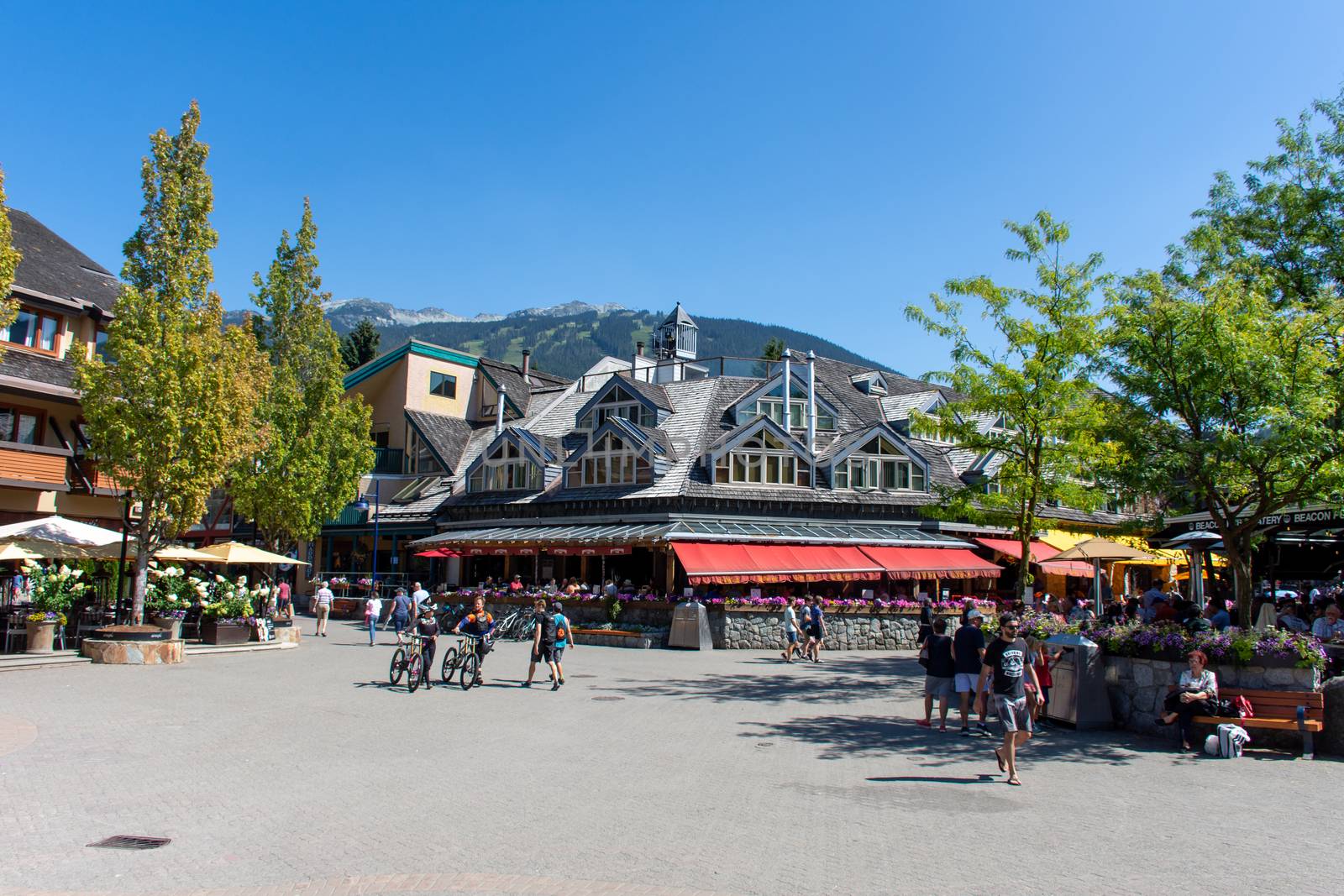 "Whistler, British Columbia/Canada - 08/07/2019: Whistler village streets during the summer looking at the walkway, street, shops and tourists and mountain bikers enjoying this Olympic world class destination."
