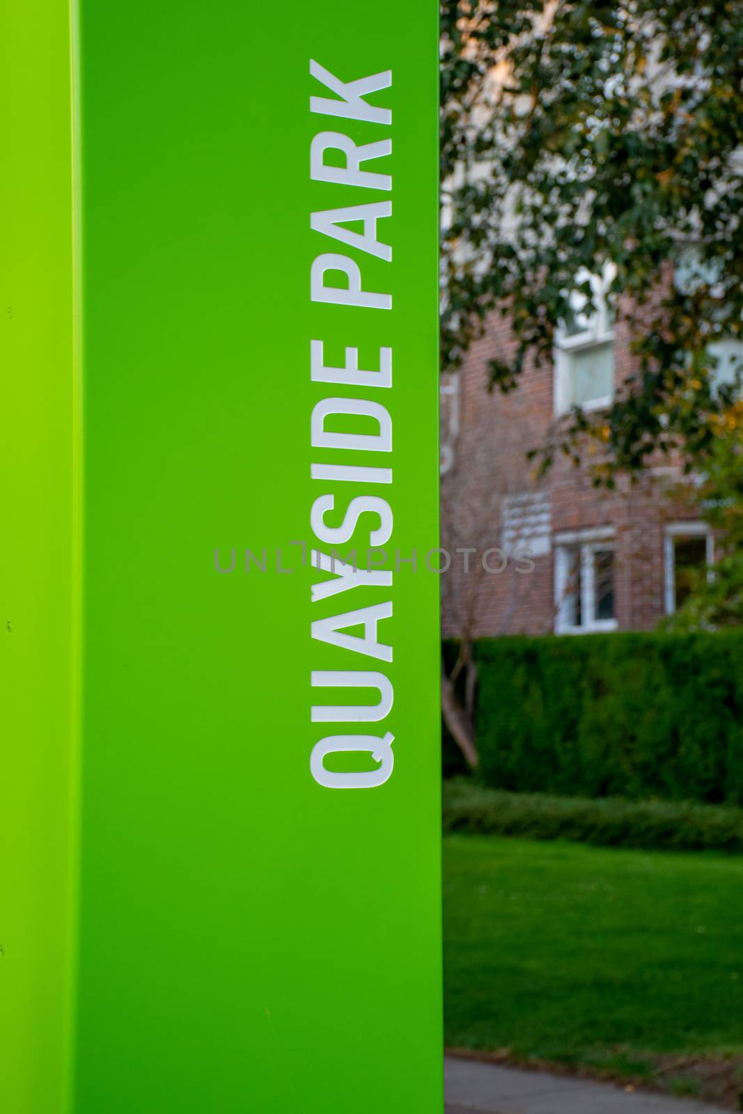 Bright Green Quayside Park sign along the New Westminster, British Columbia walkway with copy space
