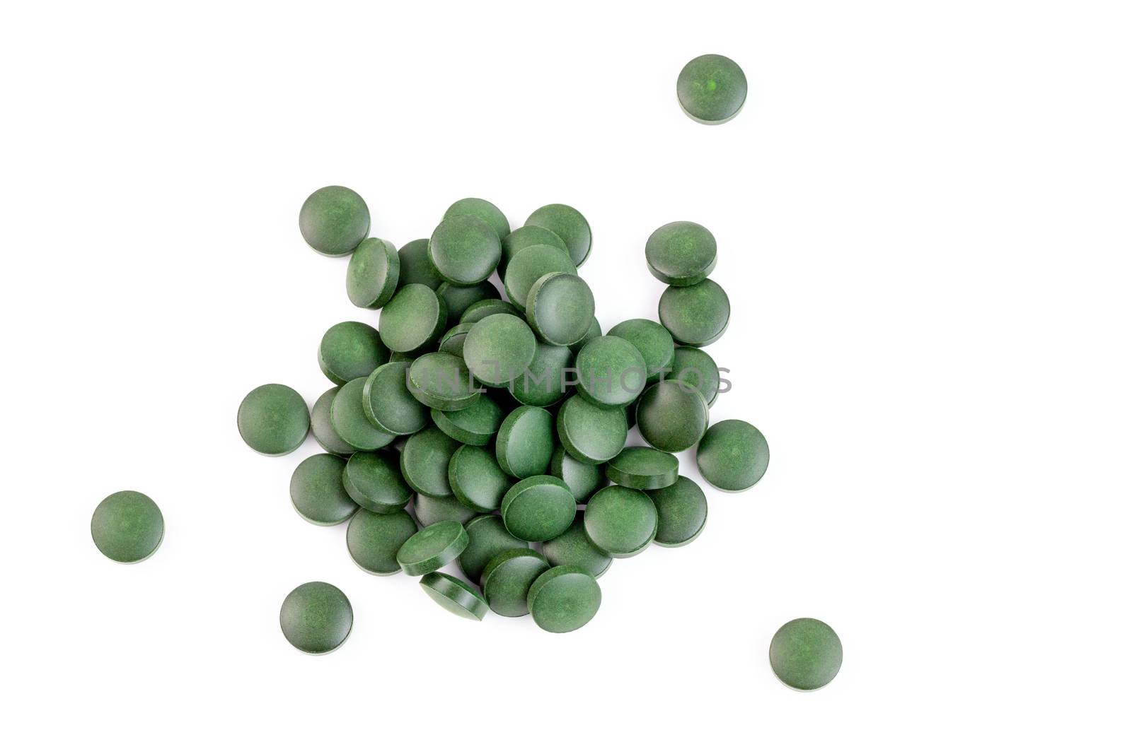 a small pile of green spirulina pills isolated on white background in linear perspective by z1b